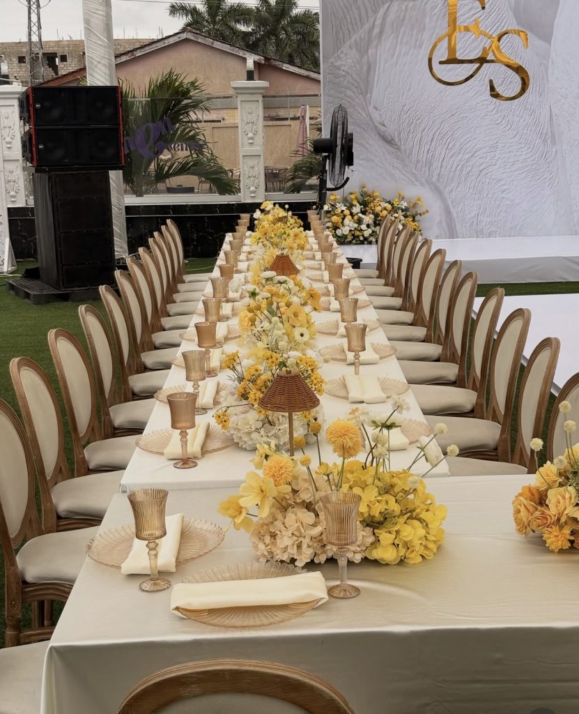 Long yellow and white traditional wedding reception table with monogram backdrop by Fems Events