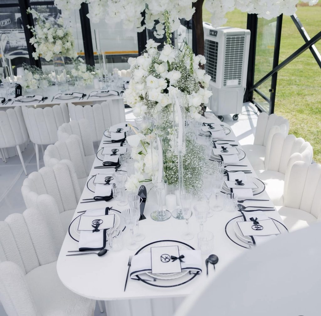 Long black and white wedding reception table with white florals by Fems Events