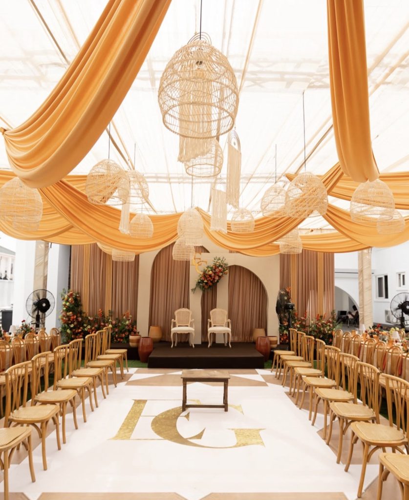 Orange and gold draped hall styled for an African traditional wedding by Fems Events