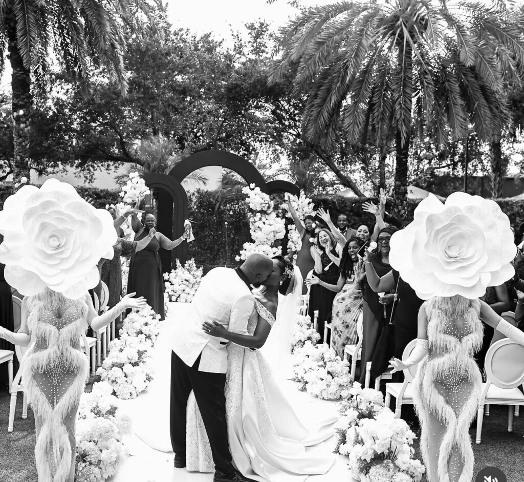 Wedding ceremony kiss with white rose aisle