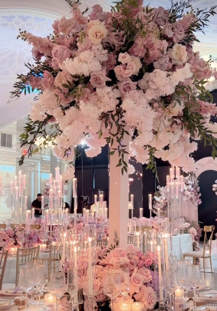 Tall pink floral wedding centerpiece with taper candles